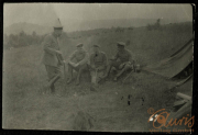 Soldaten sitzen in einem Feld nahe einem Zelt und unterhalten sich während des Ersten Weltkriegs