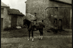 Soldat auf einem Pferd vor einer alten Steinhütte in ländlicher Umgebung