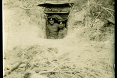 Soldaten stehen in einem Schützengraben während des Ersten Weltkriegs in einem bewaldeten Gebiet
