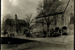 Heer zieht in eine Stadt mit Pferdewagen und einem historischen Gebäude im Hintergrund