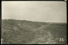 Karge Landschaft mit Trümmern und Wegweiser im Vordergrund bei Heer