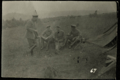 Soldaten sitzen in einem Feld nahe einem Zelt und unterhalten sich während des Ersten Weltkriegs