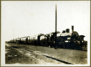 Dampflok am Bahnhof mit Waggons auf den Gleisen in historischem Setting