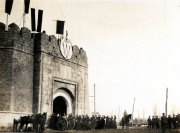 Heer versammelt sich vor historischer Stadtmauer in einem frühen 20. Jahrhundert
