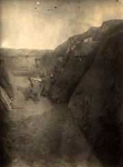 Soldaten sitzen in einem Schützengraben während des Ersten Weltkriegs in einem rauen Gelände