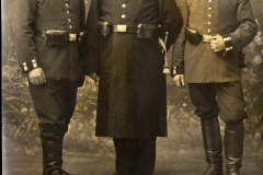 Drei Soldaten der Heertruppen in Uniform im Jahr 1915 vor einem bewaldeten Hintergrund