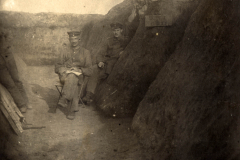 Soldaten sitzen in einem Schützengraben während des Ersten Weltkriegs in einem rauen Gelände