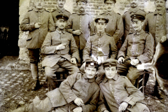 Soldaten der Heer posieren in historischer Uniform vor einer Steinmauer während des frühen 20. Jahrhunderts