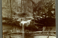 Kleinwasserfall am Elefantenbach in einem Waldgebiet mit Holzgeländer und Felsen