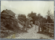 Landschaftsaufnahme einer ländlichen Gegend mit Hütten und einem Holzzaun in den Bergen