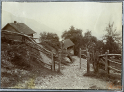 Landschaftsaufnahme einer ländlichen Gegend mit Hütten und einem Holzzaun in den Bergen