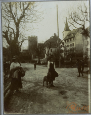 Menschen auf einer alten Straße mit einem Hund in einem historischen Dorf