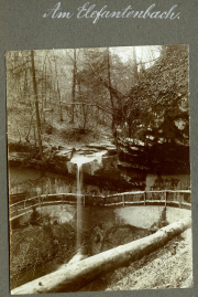 Kleinwasserfall am Elefantenbach in einem Waldgebiet mit Holzgeländer und Felsen