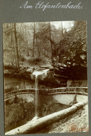 Kleinwasserfall am Elefantenbach in einem Waldgebiet mit Holzgeländer und Felsen