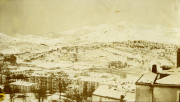 Schnee bedeckte Landschaft mit Gebäuden und Bergen während des Winters in den frühen 20. Jahrhundert