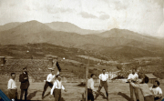 Gruppenspiel im Freien mit Blick auf die Berge in der Umgebung im Jahr 1920