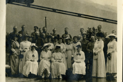 Gruppenbild von Soldaten und Frauen während eines gesellschaftlichen Anlasses im Freien in den Bergen