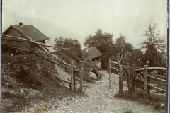 Landschaftsaufnahme einer ländlichen Gegend mit Hütten und einem Holzzaun in den Bergen