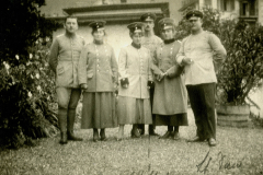 Heer und weibliche Angehörige in historischer Uniform in einem Garten