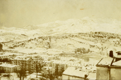 Schnee bedeckte Landschaft mit Gebäuden und Bergen während des Winters in den frühen 20. Jahrhundert