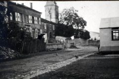 Blick auf eine ruhige Straße mit historischen Gebäuden und einer kleinen Hütte in einem Dorf