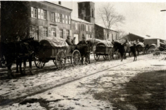 Transport von Gütern mit Pferdefuhrwerken in einer verschneiten Landschaft