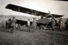 Keine Identifikation des Flugzeugs, ein Heer mit Soldaten und Zivilisten auf einem Feld zwischen 1914 und 1918