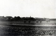 Historische Landschaft mit landwirtschaftlichen Feldern und alten Gebäuden in der Nähe eines kleinen Dorfes
