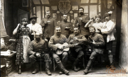Soldaten in traditioneller Kleidung versammeln sich während eines geselligen Abends in einem historischen Raum