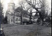 Historisches Anwesen mit Turm und alten Bäumen in einem ländlichen Gelände