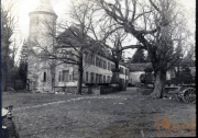 Historisches Anwesen mit Turm und alten Bäumen in einem ländlichen Gelände