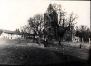 Verfallene Kirche mit beschädigtem Turm und umliegendem Gelände in ländlicher Gegend