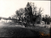 Verfallene Kirche mit beschädigtem Turm und umliegendem Gelände in ländlicher Gegend