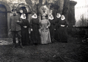 Gruppenbild von Soldaten und Nonnen vor historischem Hintergrund im frühen 20. Jahrhundert