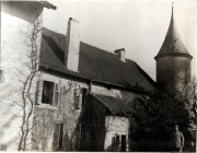 Ein historisches Herrenhaus mit Aussichtsturm umgeben von Natur im frühen 20. Jahrhundert