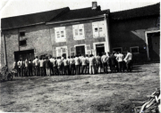 Menschen versammeln sich vor einem Gebäude in einem ländlichen Gebiet während eines historischen Ereignisses