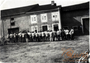 Menschen versammeln sich vor einem Gebäude in einem ländlichen Gebiet während eines historischen Ereignisses