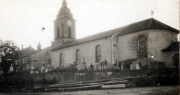 Heimelige Atmosphäre in einem historischen Dorf mit Kirche und Friedhof am frühen Morgen