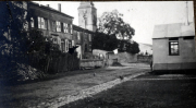 Blick auf eine ruhige Straße mit historischen Gebäuden und einer kleinen Hütte in einem Dorf