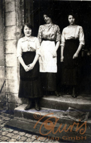 Drei Frauen stehen gemeinsam vor einem historischen Gebäude in der Stadt