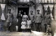 Gruppenfoto von Soldaten und Zivilisten vor einem Gebäude in einer ländlichen Umgebung