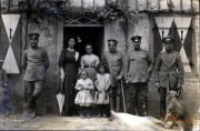 Gruppenfoto von Soldaten und Zivilisten vor einem Gebäude in einer ländlichen Umgebung