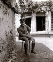 Soldat der Heer auf einem Hocker vor einem alten Gebäude in einer ländlichen Umgebung