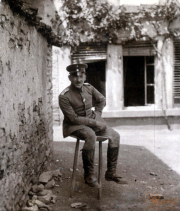 Soldat der Heer auf einem Hocker vor einem alten Gebäude in einer ländlichen Umgebung