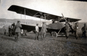 Keine Identifikation des Flugzeugs, ein Heer mit Soldaten und Zivilisten auf einem Feld zwischen 1914 und 1918
