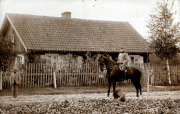 Reiter in Uniform neben einem historischen Haus während des späten 19. Jahrhunderts
