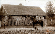 Reiter in Uniform neben einem historischen Haus während des späten 19. Jahrhunderts