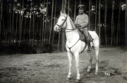 Ein Soldat der Heer reitet auf einem weißen Pferd in einem Waldgebiet