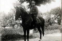 Soldat auf einem Pferd steht unter einem Baum am 15. August 1915