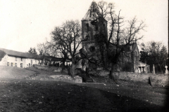 Verfallene Kirche mit beschädigtem Turm und umliegendem Gelände in ländlicher Gegend